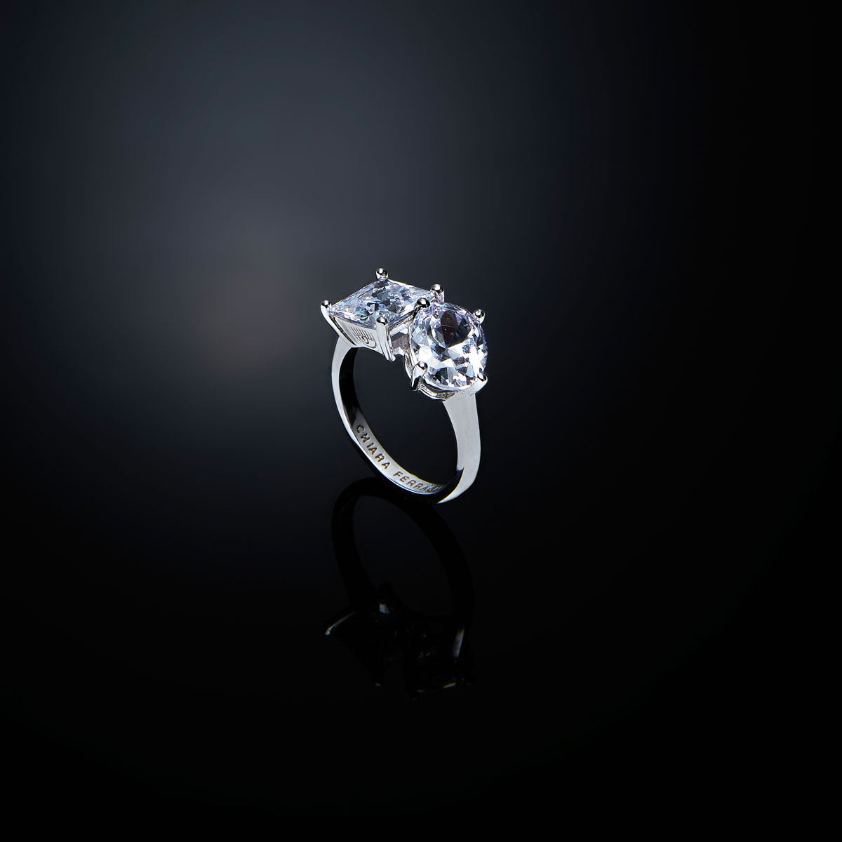 Anello da donna con due zirconi bianchi, uno taglio brillante e l'altro taglio ovale. Finitura in platino. Disegnato da CHIARA FERRAGNI.