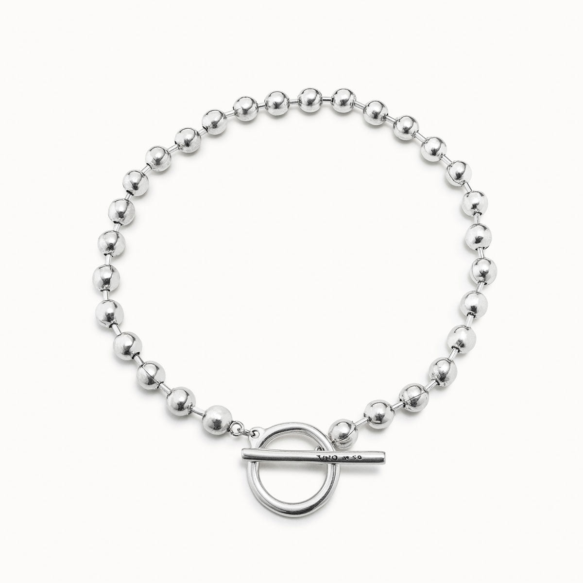 Girocollo ON-OFF da donna formato da varie sferette che culminano con una preziosa chiusura formata da un cerchio con inciso il logo UNOde50 e una barretta funzionale e ornamentale. Realizzato interamente a mano in Spania.