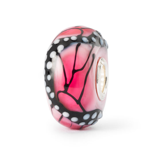 Ali della Passione è un beads in vetro Trollbeads su cui è disegnata una farfalla rosa e nera con puntini bianchi.