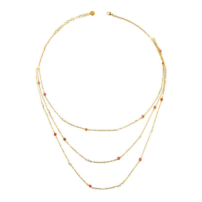 Girocollo a 3 fili con perline bianche e zirconi rossi incastonati a mano. I tre fili sono in argento 925 con finitura in oro giallo 18kt e hanno lunghezze diverse.